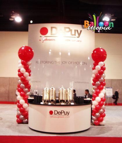 Large balloon columns help this trade show booth attract attention